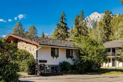 a house with a mountain in the background at Gateway Suites Single Private Room Near Banff and Canmore in Canmore