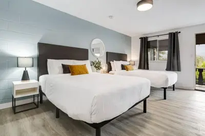 a bedroom with two beds and a mirror at Gateway Suites Private Double room Near Canmore and Banff in Canmore