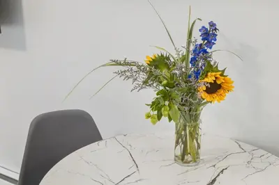 a vase filled with flowers sitting on a table at Gateway Suites Private Double room Near Canmore and Banff in Canmore