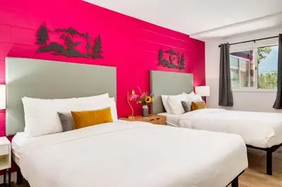 two beds in a room with a red wall at Gateway Suites Rocky Mountains Private Double room close to Banff in Canmore