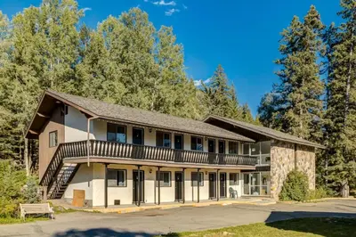 an apartment building with a balcony and trees at Gateway Suites Rocky Mountains Private Double room close to Banff in Canmore