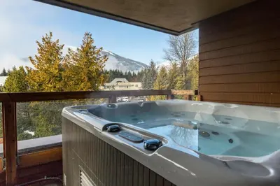 a jacuzzi tub on a balcony with a view at Whistler Village Retreat, Private Hot Tub & Sauna in Whistler
