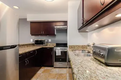 a kitchen with stainless steel appliances and brown cabinets at Whistler Village Retreat, Private Hot Tub & Sauna in Whistler