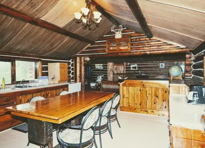 a dining room with a wooden table and chairs at Country Rustic Loghouse at Teepee Meadows in Valemount
