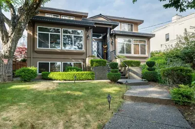 a house with a grass yard in front of it at Adorable, 2 Bedrooms in West Vancouver in West Vancouver