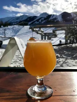 a glass of beer sitting on top of a table at Chancellor Peak 1BR and Loft Wooden Cabin near Lake Louise in Golden