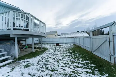 a backyard with snow on the ground and a fence at A beautiful 2 bedroom private home in Hinton