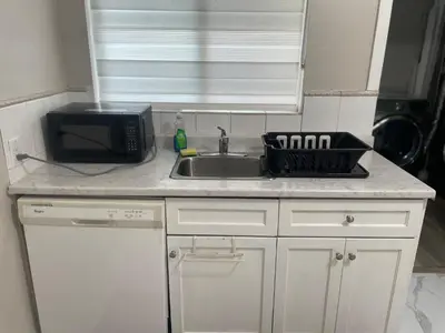 a kitchen counter with a sink and a microwave at Central Vally Private House in Abbotsford