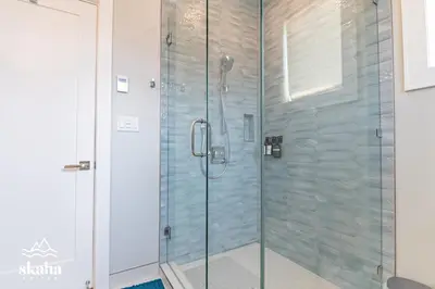 a shower with glass doors in a bathroom at Skaha Suites in Penticton