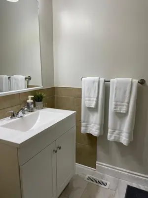 a bathroom with a sink and a mirror and towels at Home beside WEM in Edmonton