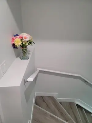 a vase of flowers sitting on a shelf in a room at Cozy Suite near West Edmonton Mall in Edmonton