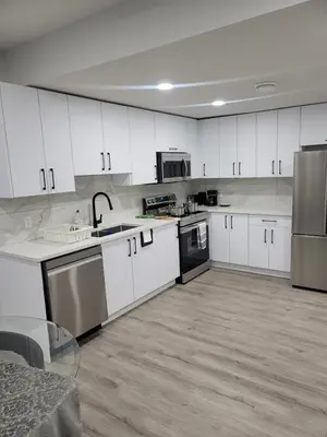 a kitchen with white cabinets and stainless steel appliances at Cozy Suite near West Edmonton Mall in Edmonton