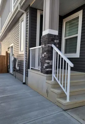 a house with a white railing on a porch at Cozy Suite near West Edmonton Mall in Edmonton