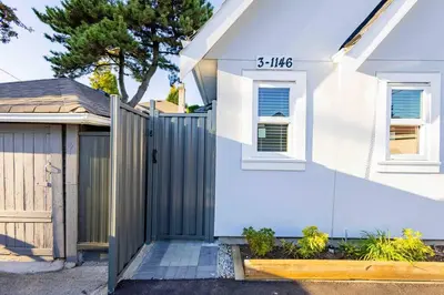 a white house with a gate and a fence at Charming & Brand-New near Restaurants & Transport in Vancouver