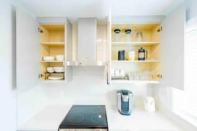 a kitchen with white cabinets and a stove at Charming & Brand-New near Restaurants & Transport in Vancouver