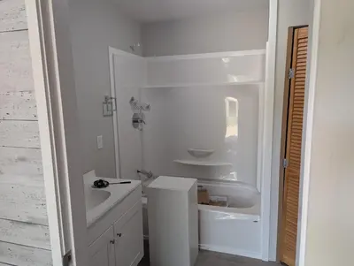 a white bathroom with a sink and a toilet at Bela bahia in Qualicum Beach