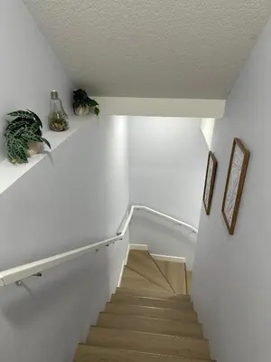 a staircase in a house with white walls and wooden floors at Peaceful Haven in Prime Location in Calgary