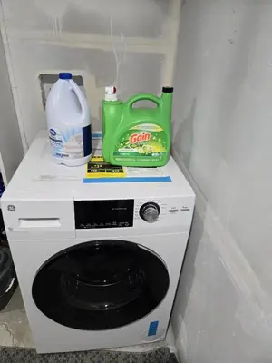 a washing machine with a jug of milk and a detergent at Cozy Basement Suite, SW Calgary in Calgary