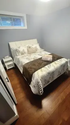 a bed in a room with a bedskirtspectspectssenalsenalsenalsenalsenal at Quiant 2 Bedroom Suite in Vancouver