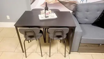 a black table with chairs and a bottle of wine at Quiant 2 Bedroom Suite in Vancouver