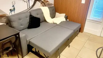 a grey couch in a living room with a table at Quiant 2 Bedroom Suite in Vancouver