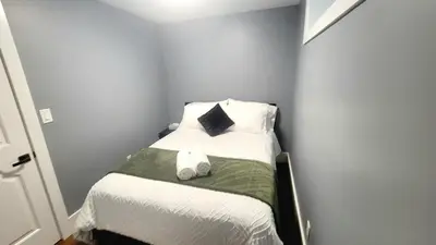 a small bedroom with a bed with two shoes on it at Quiant 2 Bedroom Suite in Vancouver