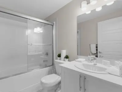 a white bathroom with a toilet and a sink at Superb 1-Bdr Apt in New Condo in Calgary