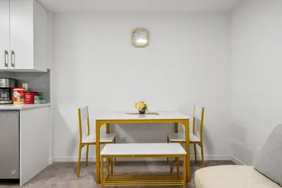 a table and chairs in a room with a kitchen at Private Basement Magnolia Retreat Family Friendly Suite near Seton and Lake in Calgary