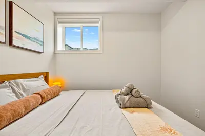 a bedroom with a bed with a teddy bear on it at Cozy 2BR BSMT Suite with Board Games and Netflix in Calgary