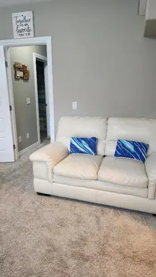 a white couch with blue pillows in a living room at Oasis at Heritage in Fort McMurray
