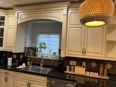a kitchen with white cabinets and a sink and a light at Luxury New 5-bedroom 4- bathroom Single House in Surrey