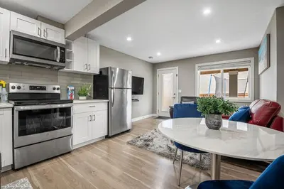 a kitchen and dining room with a table and a kitchen with at Cozy & Large Furnished 2-Bedroom Suite in Calgary