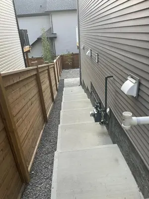 a sidewalk next to a fence next to a house at Cozy & Large Furnished 2-Bedroom Suite in Calgary