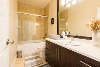 a bathroom with a sink and a toilet and a mirror at Beach Breeze White Rock in White Rock