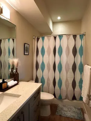 a bathroom with a toilet and a shower curtain at Oceana Retreat Cozy 1BR with Outdoor Oasis in Victoria