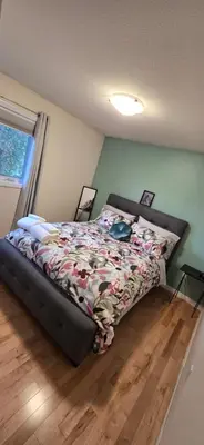 a bedroom with a bed with a comforter on it at Northern Manor in Yellowknife