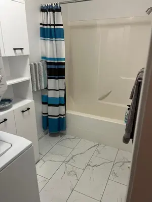 a bathroom with a tub and a shower curtain at Lake View Suite, Forest Retreat, Balfour BC in Balfour