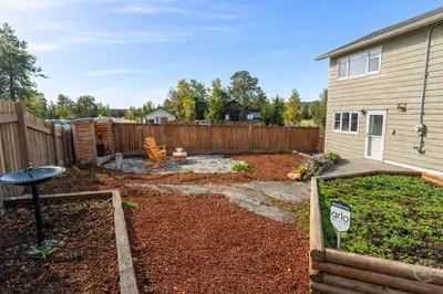 a backyard with a wooden fence and a garden at Great Northern Escapes - The Managers House in Yellowknife