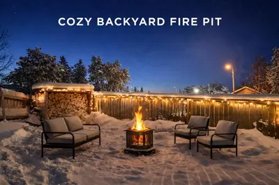 a patio with a fire pit in the snow at night at Great Northern Escapes - The Managers House in Yellowknife