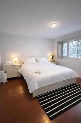 a bedroom with a large white bed and a window at Great Northern Escapes - The Managers House in Yellowknife