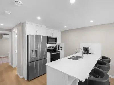 a kitchen with a refrigerator and a counter top at Exquisite 1-Bdr Condo Apt in Calgary