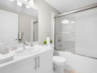 a white bathroom with a sink and a toilet at Exquisite 1-Bdr Condo Apt in Calgary