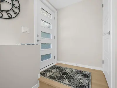 a hallway with white walls and a clock on the wall at Exquisite 1-Bdr Condo Apt in Calgary
