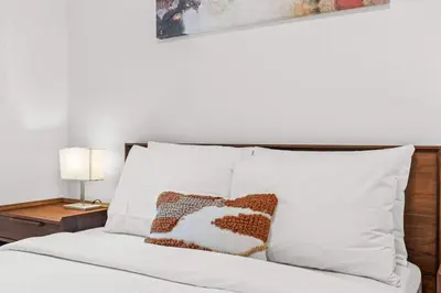a bedroom with a white bed with two pillows at Newly Built 2BR and 2BA MtnView Retreat in DT Canmore in Canmore