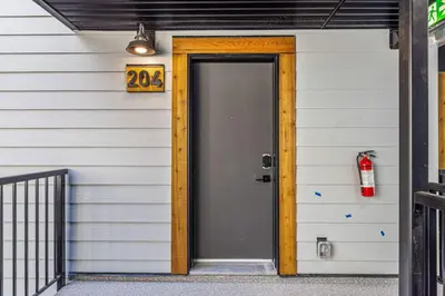 a door to a house with a fire hydrant on it at Newly Built 2BR and 2BA MtnView Retreat in DT Canmore in Canmore