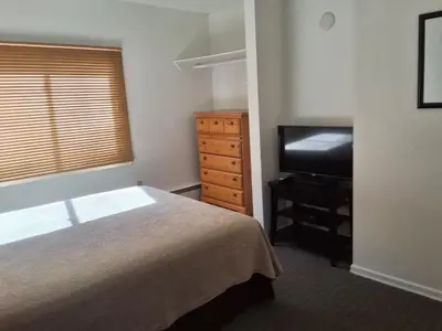 a bedroom with a bed and a dresser and a television at Wildwood Hotel in Wildwood