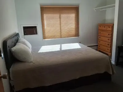 a bedroom with a bed and a dresser and a window at Wildwood Hotel in Wildwood