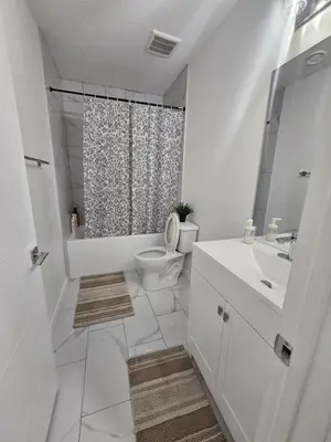 a white bathroom with a toilet and a sink at Non Smoking- Stylish Basement Suite Near Airport, Trails & Dining in Edmonton
