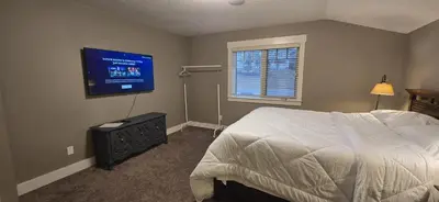 a bedroom with a bed and a flat screen tv at Rocky View Bed & Breakfast in Calgary