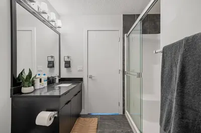 a bathroom with a glass shower and a sink at NEW Restful Retreat with Hot Tub, King Bed, AC, Garage, Near WEM in Edmonton